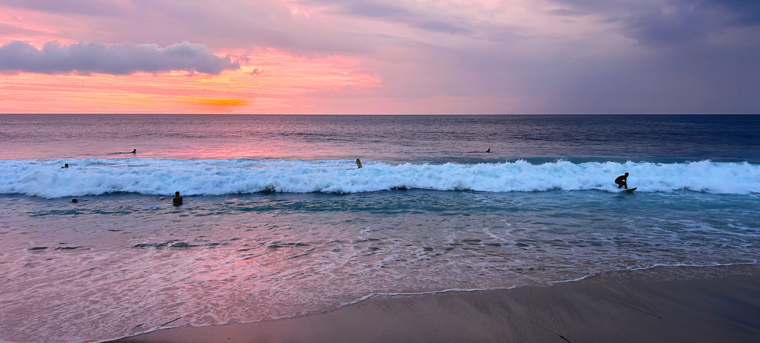 Sunset west coast of Lombok Island near Bali, surfers and beach